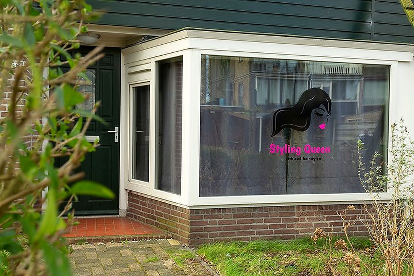 Overzicht van de salon met behandelbed, wasbak en kapselstoel
