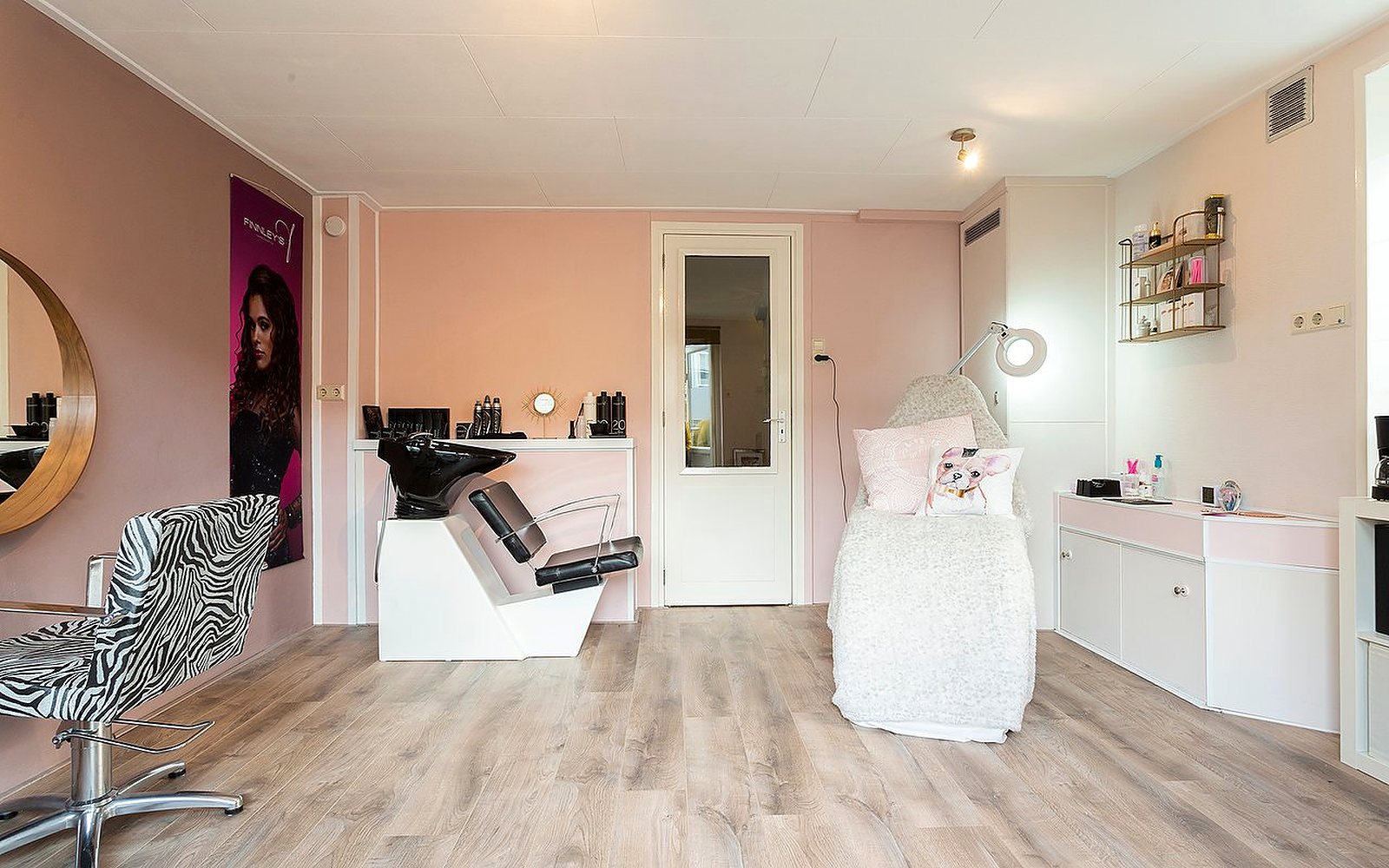 Interieur van Styling Queen: roze wanden, wasbak en behandelstoel